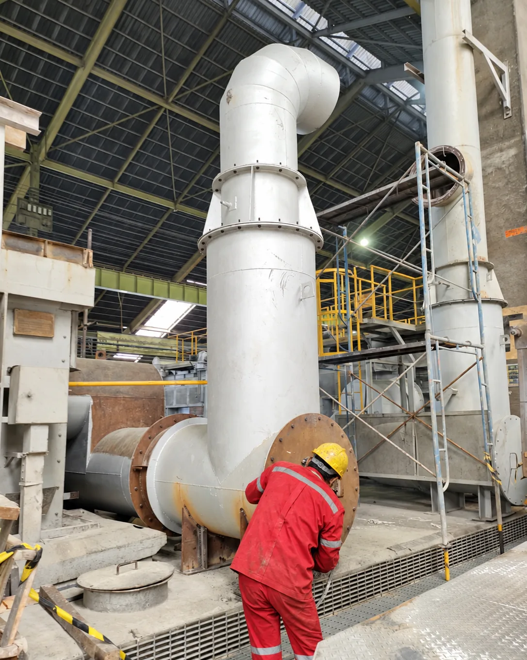 MWT technician working on a stainless steel duct connection inside an industrial plant