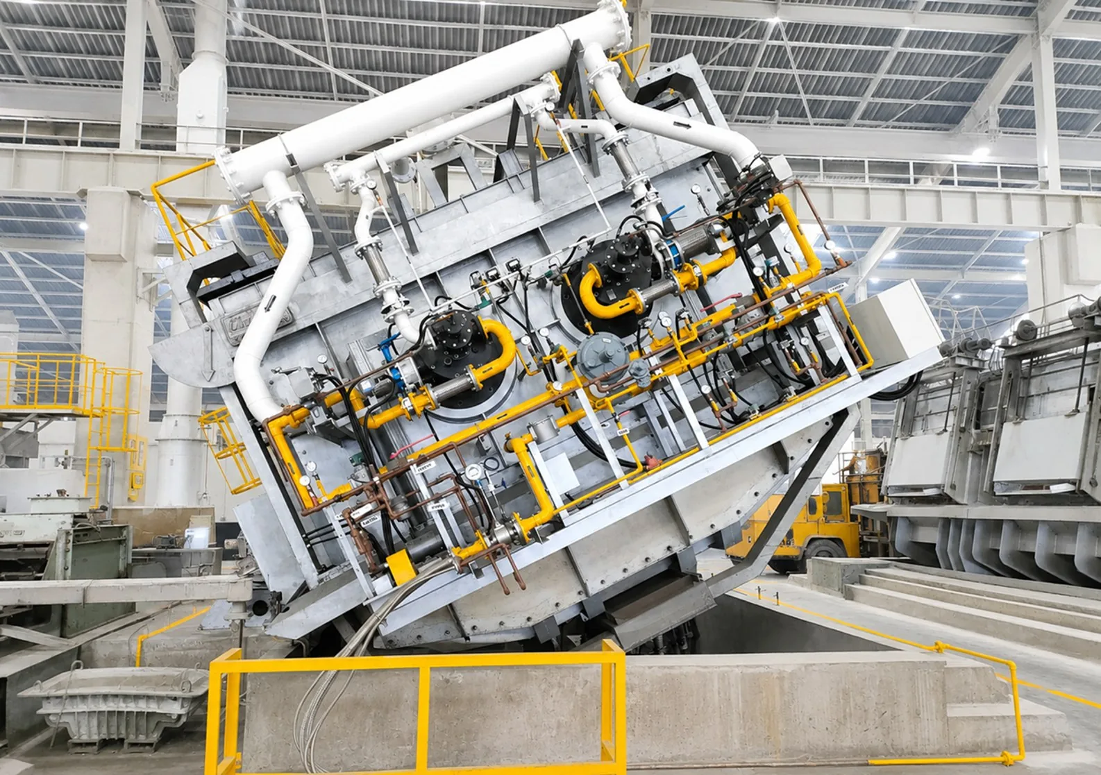 Aluminium reverberatory furnace in tilted position showing burners, gas train and exhaust piping